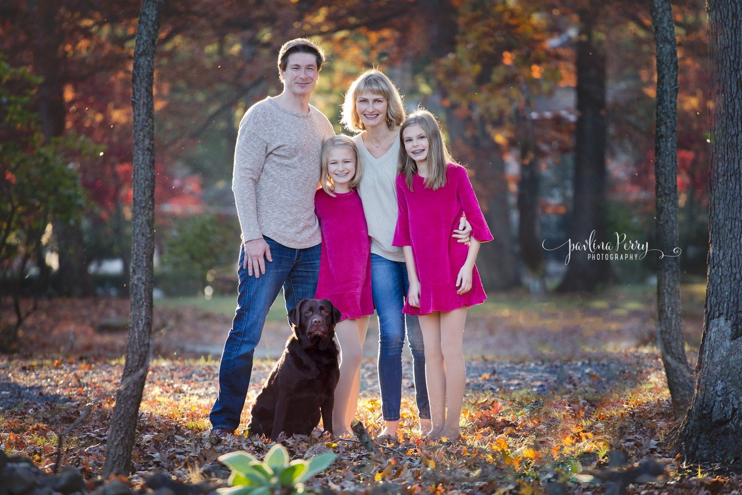 Family of four with their dog in autumn woods