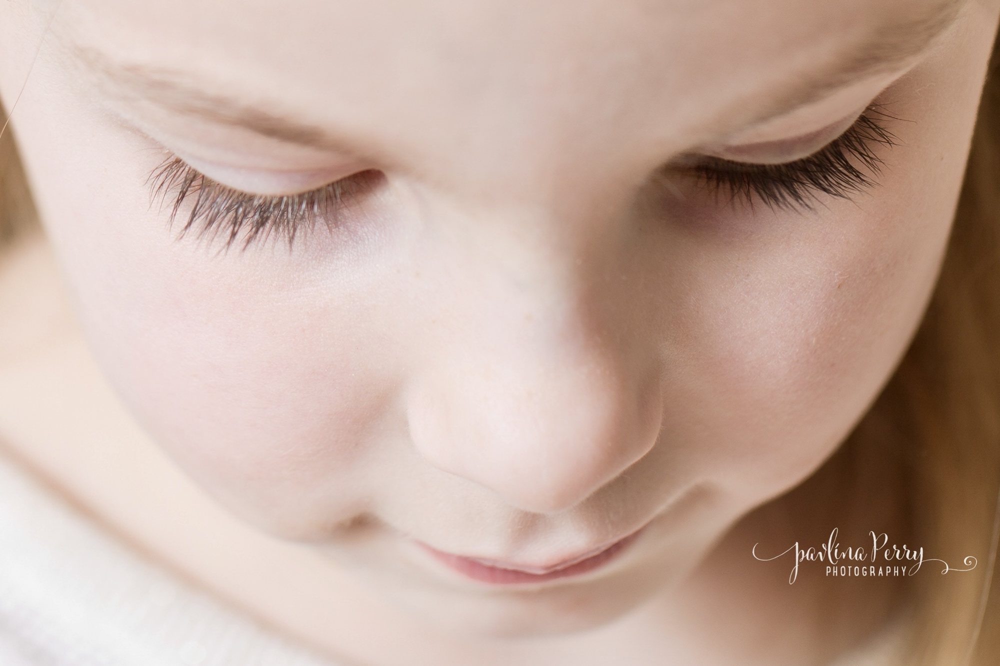 Softly lit close-up of a child with lowered eyes