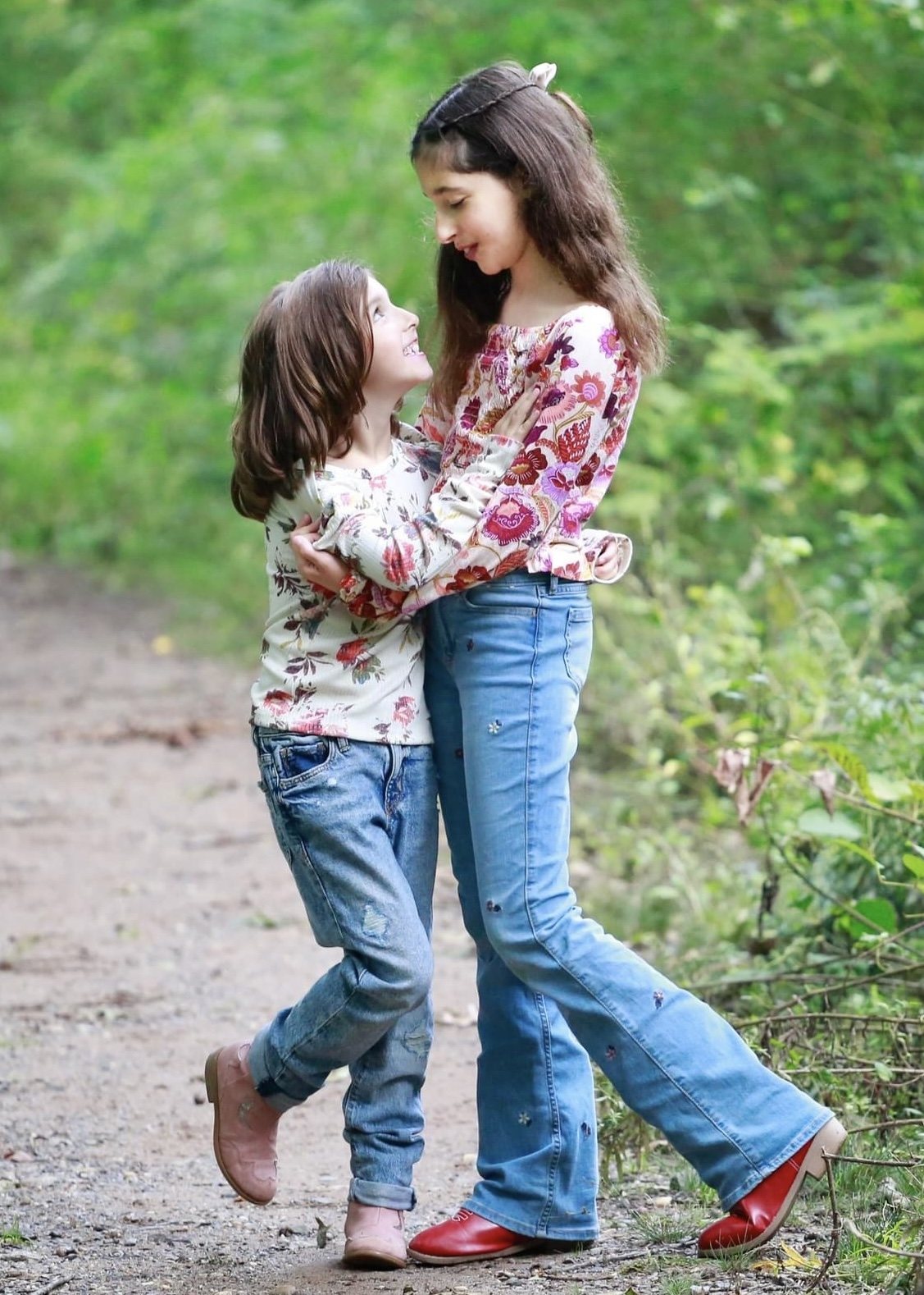 Two sisters embracing on a woodland path